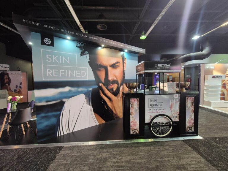 Front view of Rite Aid Health Care stand showing SKIN REFINED branding and reception desk
